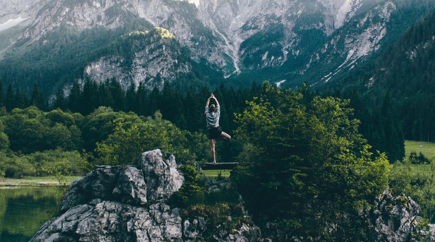 Eine Frau auf einem Berg. Sie macht Yoga